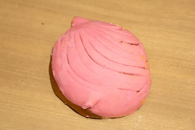 Pink concha with its shell-patterned sugar topping